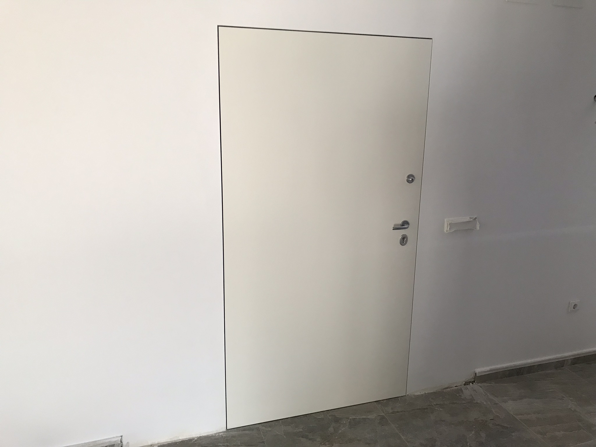 Puerta acorazada con bisagras ocultas de medida 1150 en acabado interno raso muro sin tapajuntas a la vista